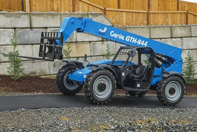 Genie telehandler placing concrete block over a wall
